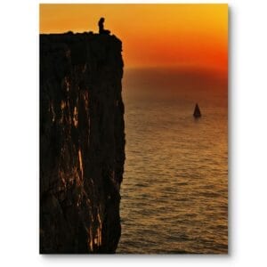 Plakat do biura nowoczesny krajobraz zachód słońca osoba na klifie pomarańczowo-żółty